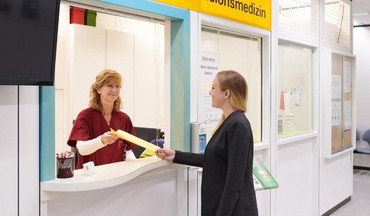 Sekretariat der Transfusionsmedizin überreicht Formular an Spenderin.